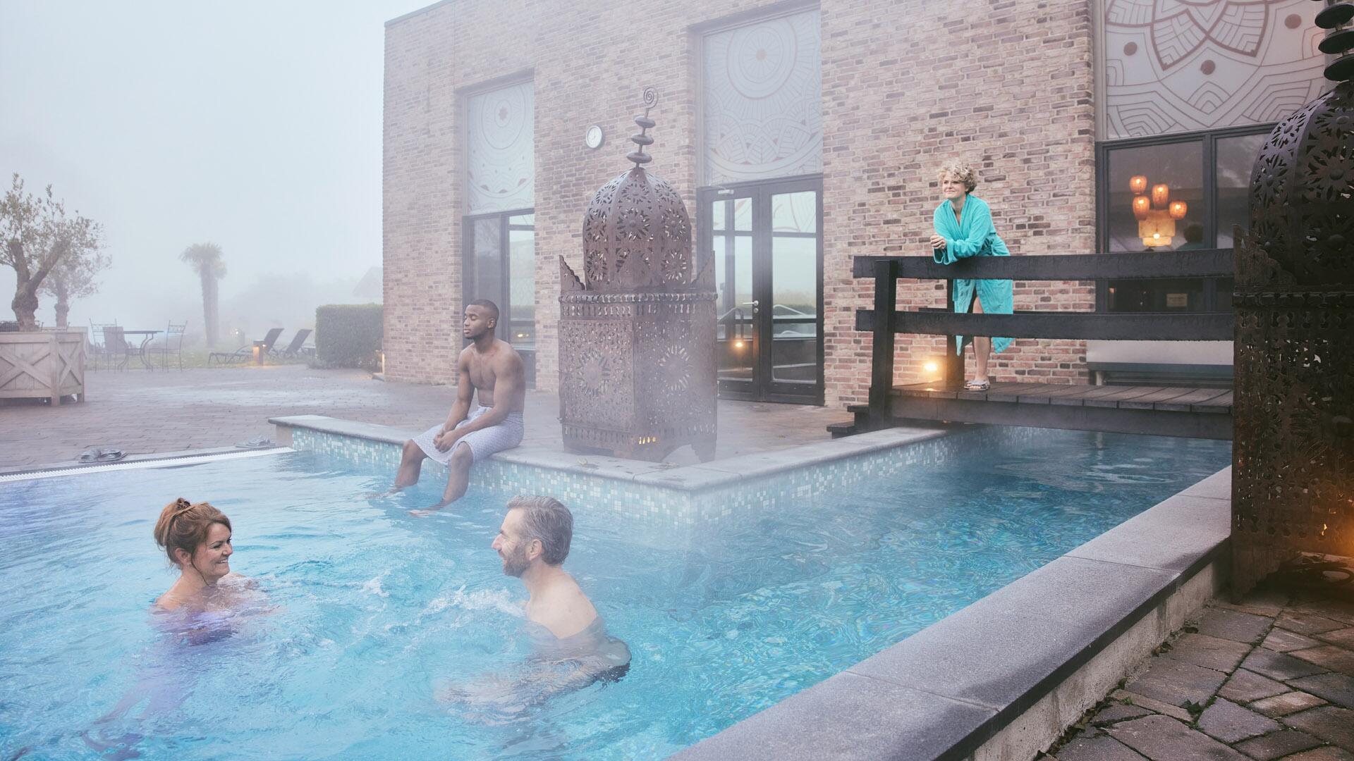 Bezoekers relaxen in buitenbad van SpaWeesp