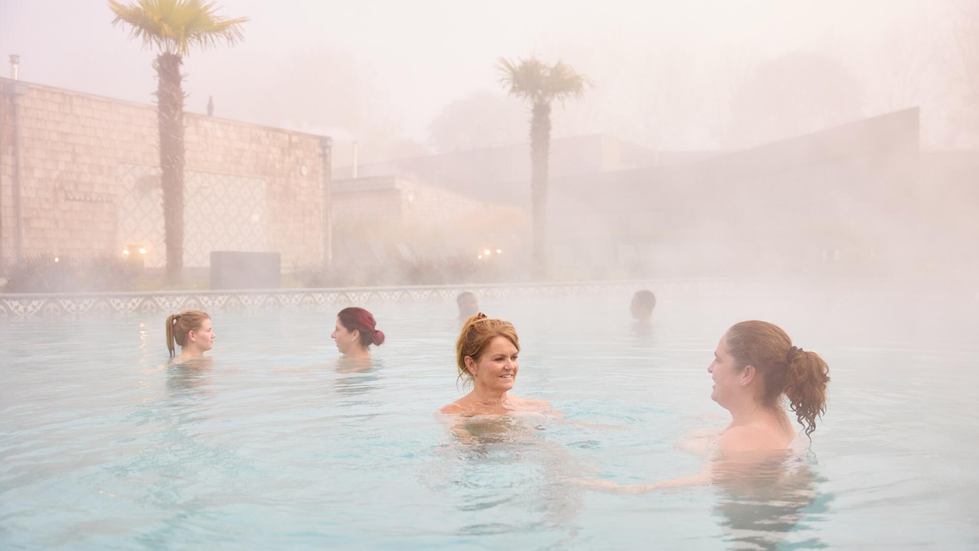 Gasten relaxen in het buitenbad van SpaWeesp tijdens de winter
