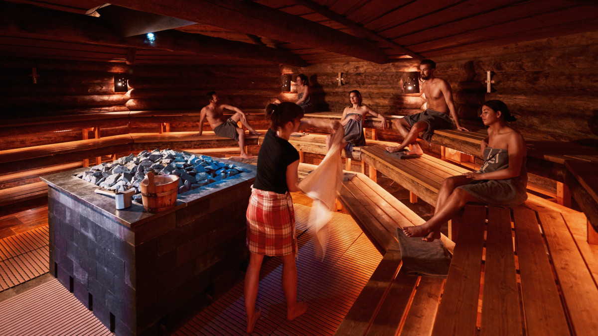 Een groep gasten ontspannen van een opgieting in de kelosauna van Thermen Holiday